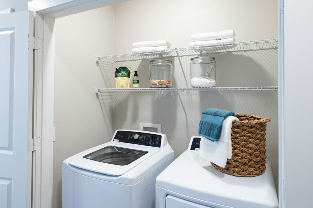 Embrace an Upscale Lifestyle - full-size washer and dryer in a closet with metal shelves